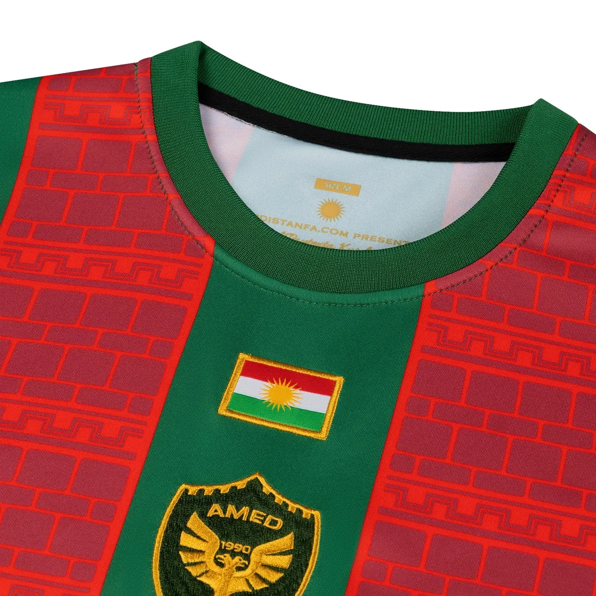 Gros plan du drapeau du Kurdistan brodé et du blason à l'aigle doré AMED 1990 du maillot domicile