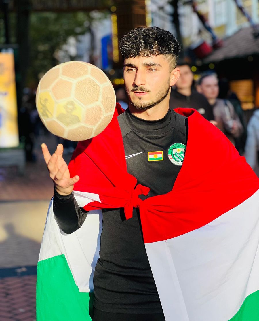 Freestyler kurde enveloppé dans le drapeau, ballon à la main