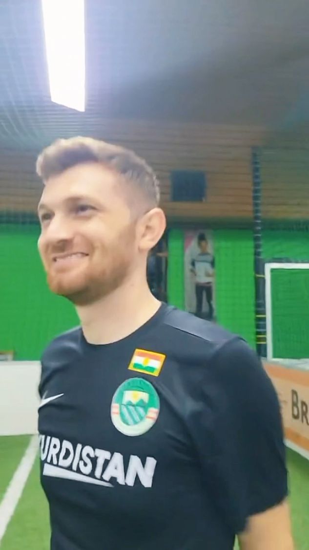 Jeune homme kurde souriant en maillot Kurdistan sur le terrain